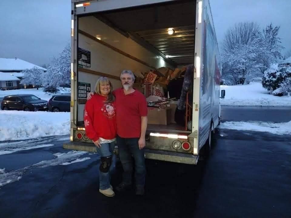 Bethany Nelson-Lieser and Brian Lieser standing by a holiday donation truck